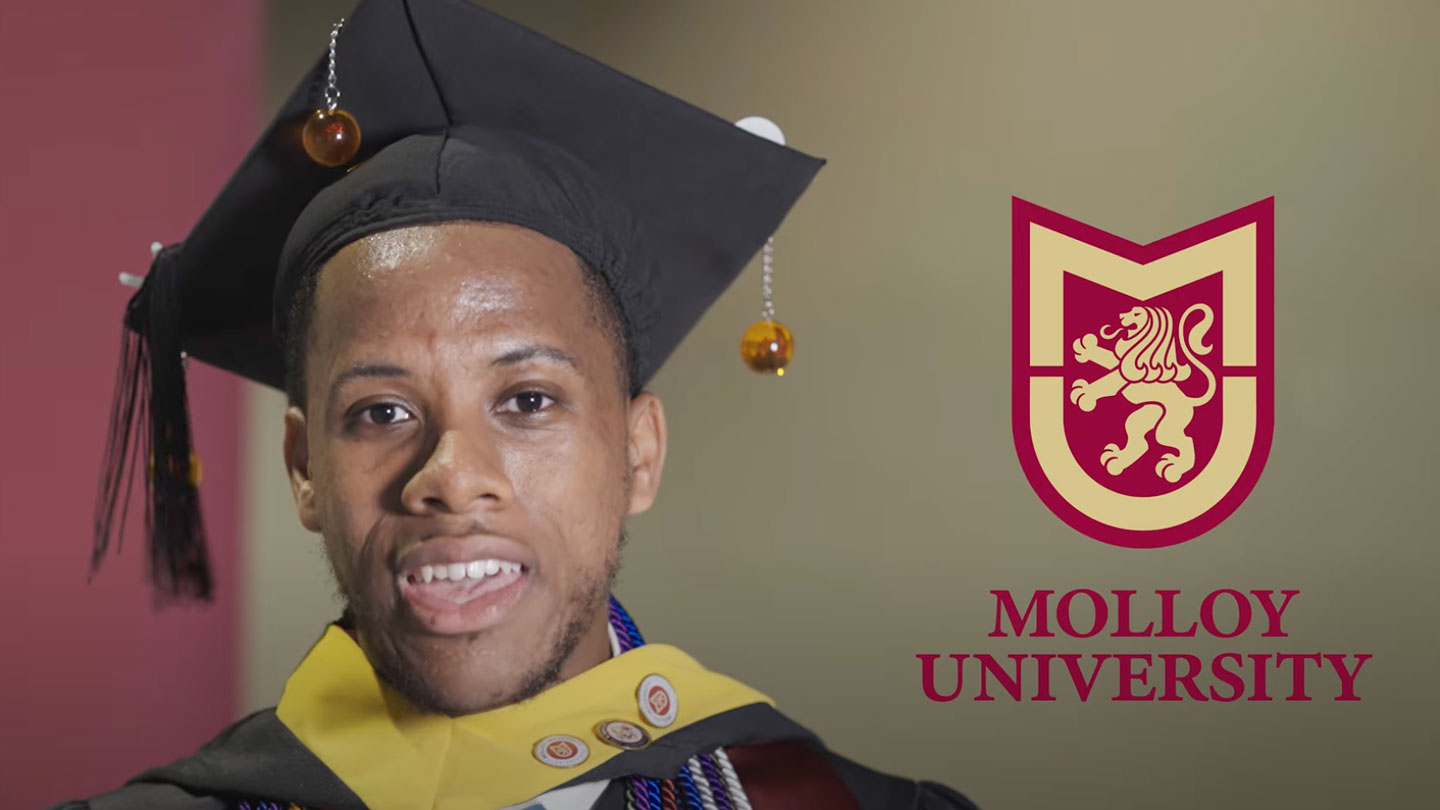 Moses Alfonso speaking into a microphone about his experience at Molloy University at Commencement