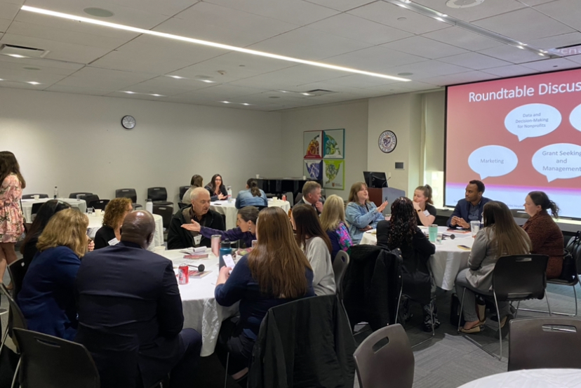 Conference attendees engaged in roundtable discussions by topic.