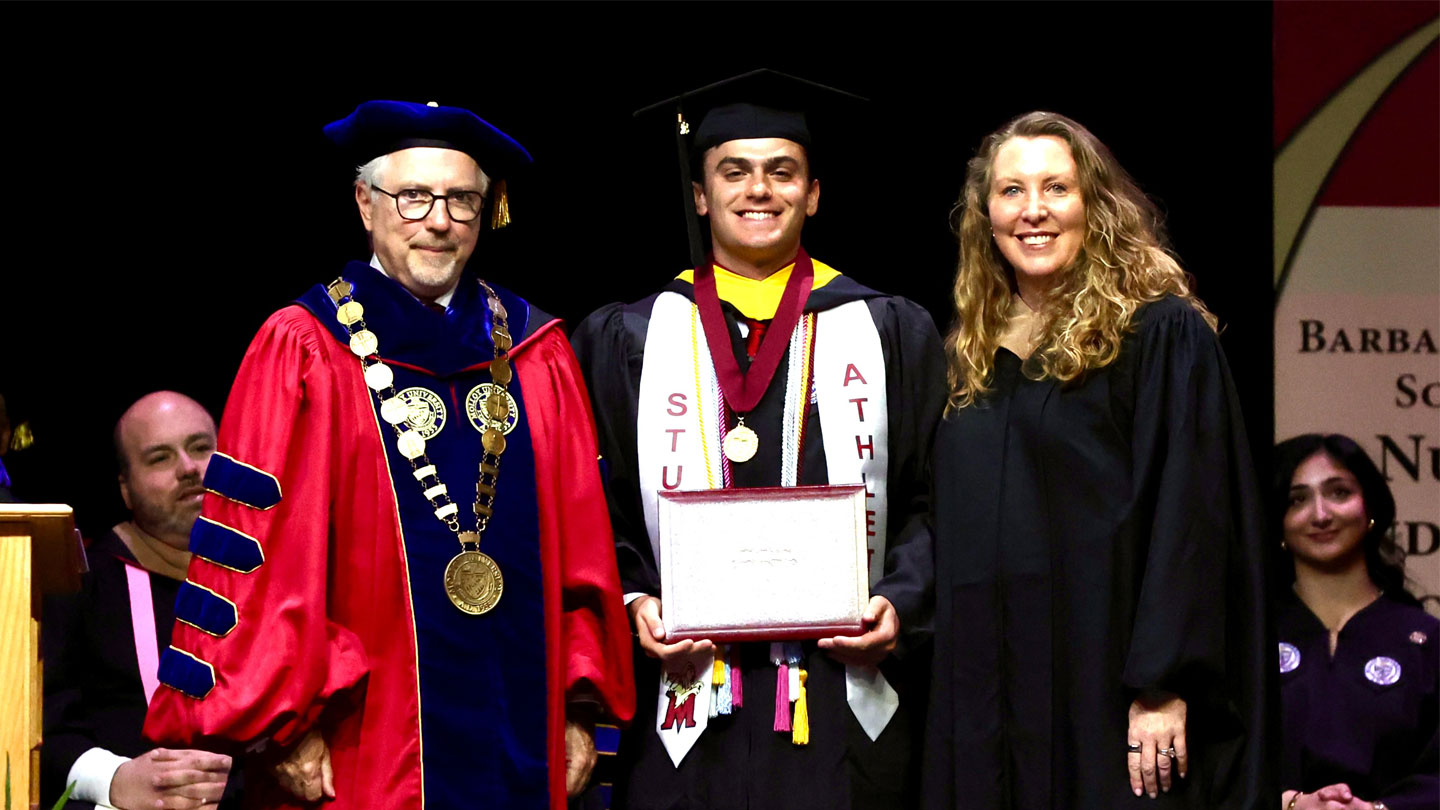 Jason Schwartz receiving diploma at graduation from James Lentini and Dean for the School of Business