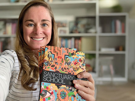 Professor Miranda holding her book, "Sanctuary School"