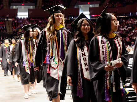 Molloy University graduates walking to receive their diplomas