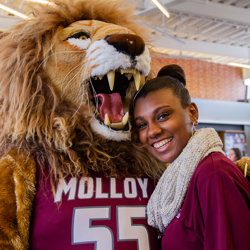 Molloy's mascot, Victor E Lion, with a student