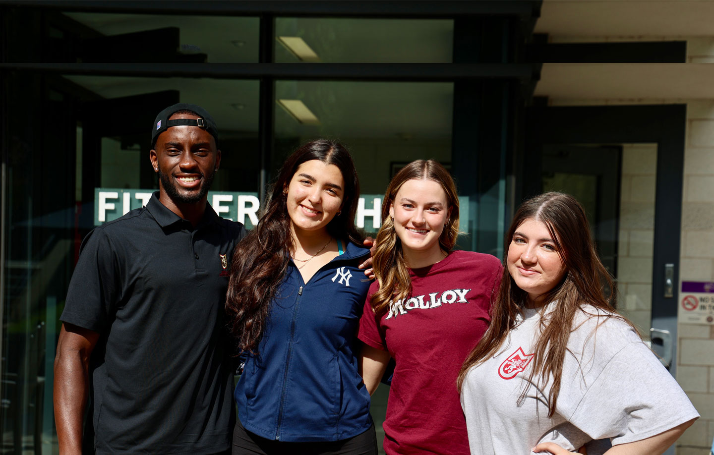 Molloy University students gathered together smiling on campus