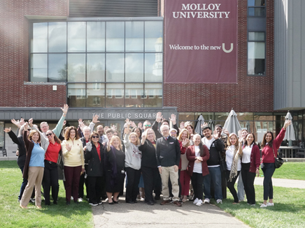 Group photo of faculty and staff on the public square lawn celebrating