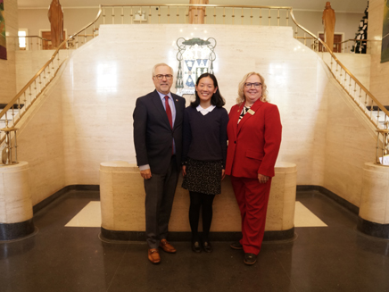 Salutatorian Grace Wilson posed smiling with president and vice president of Molloy University 