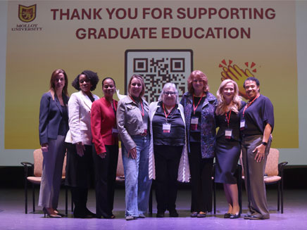 Literacy Conference panelists stand together smiling on stage.