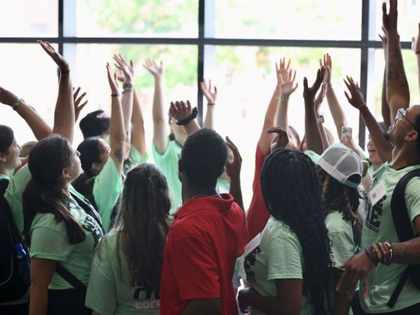 New Student Orientation Team 2024 raising their hands together