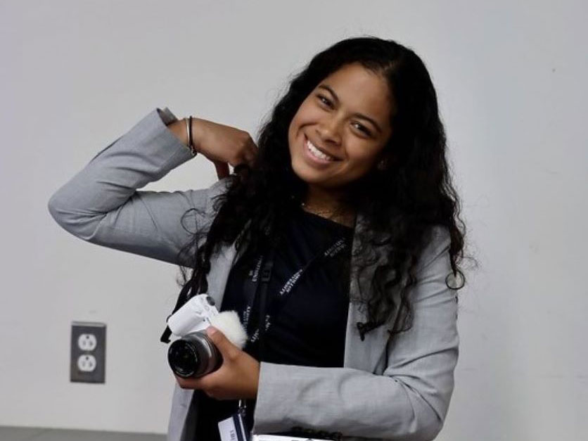 Student Orientation Leader with camera smiling