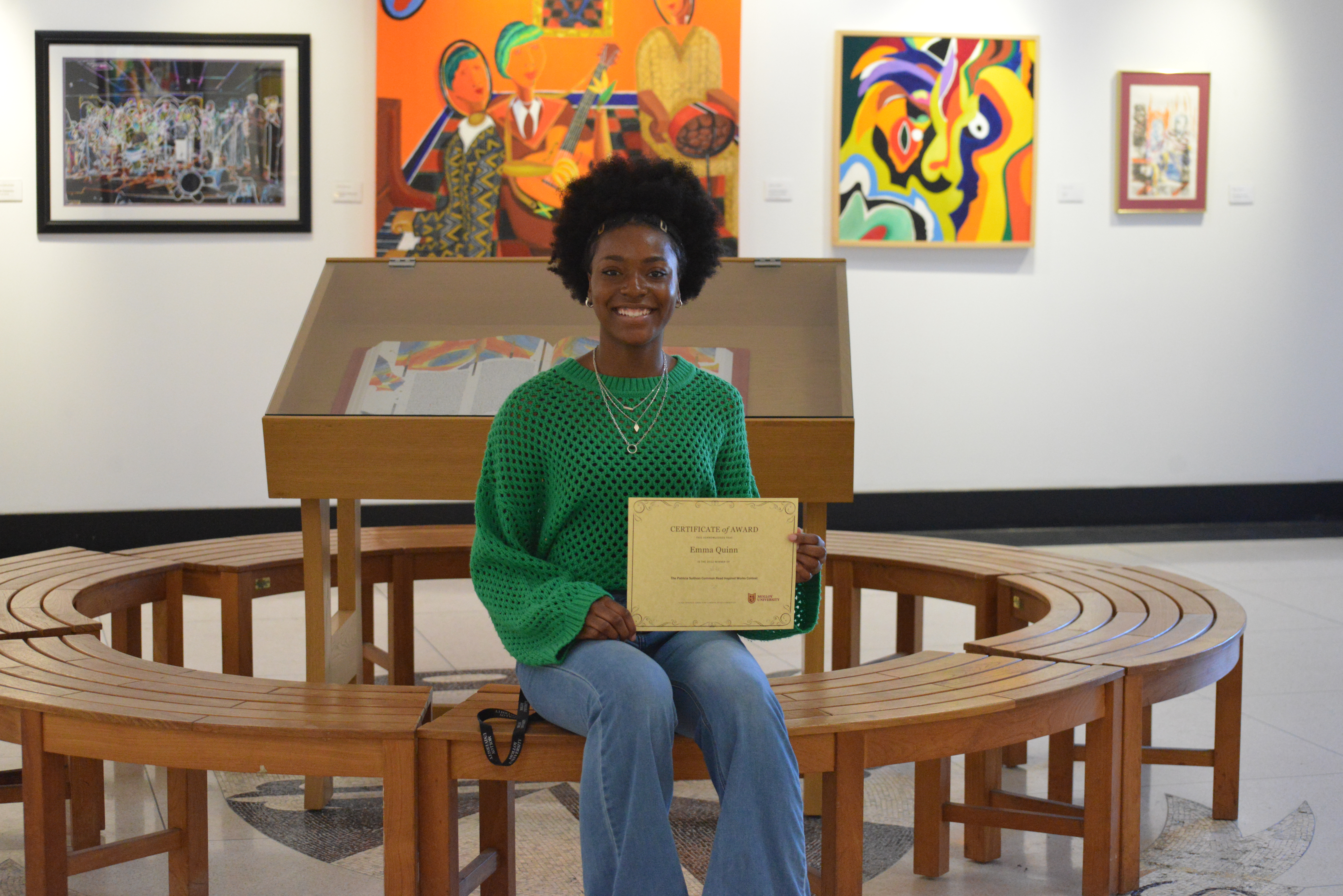 Emma Quinn, winner of "Inspired Works" sits down at Molloy University campus holding award