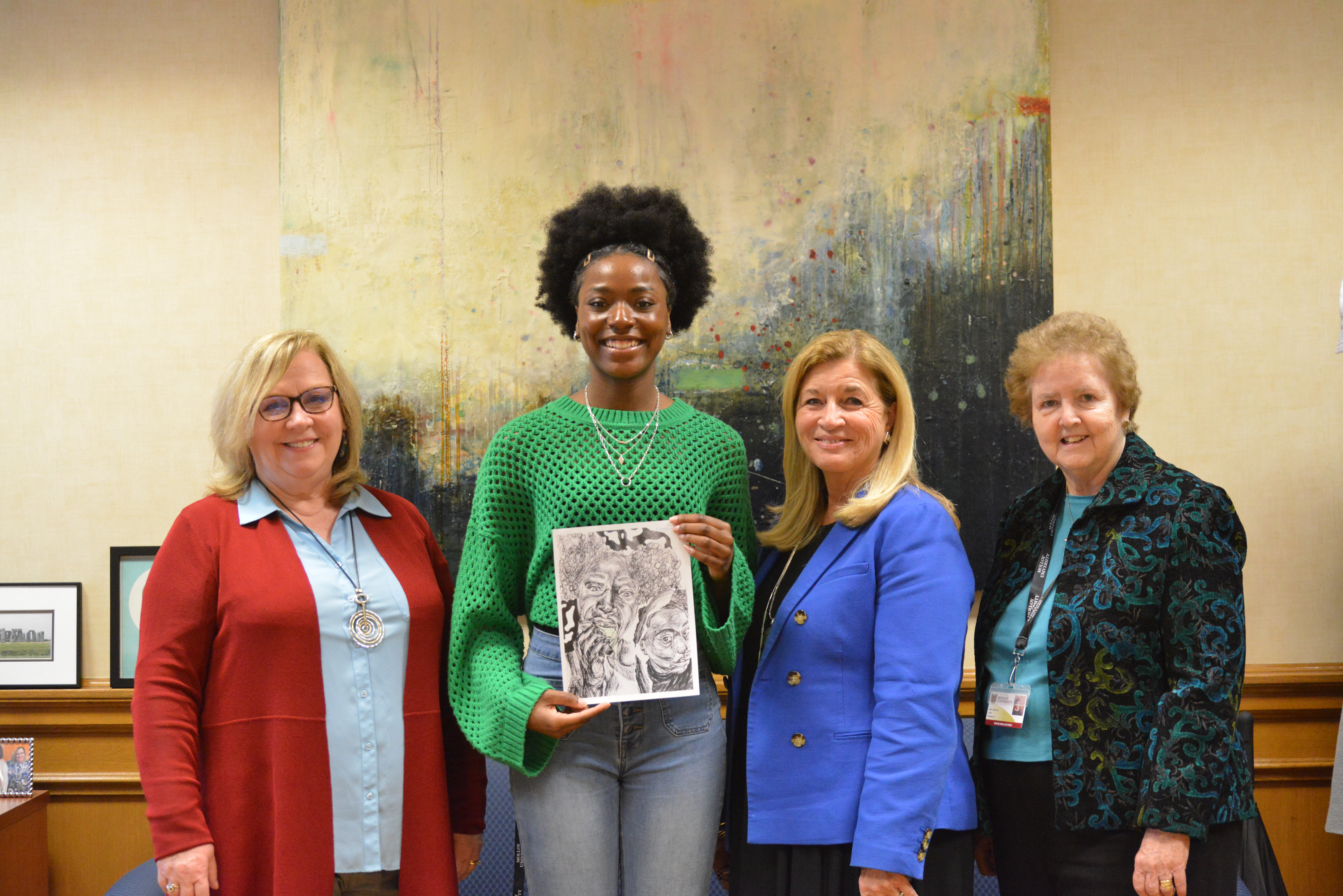 A group picture of Emma Quinn holding her artwork standing next to provost Michelle Piskulich, associate provost Barbara T. Schidmt. Ph. D, and Chairperson of the Common Reading Committee, Alice Bryce, O.P., D.A., 