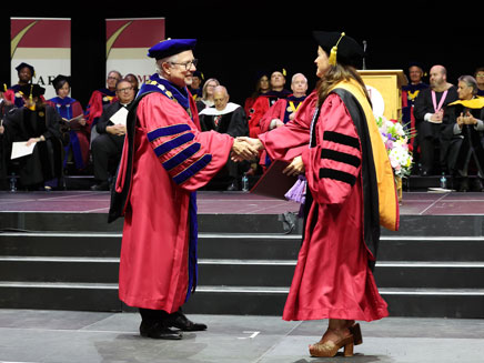James Lentini shaking hands with Molloy University doctoral graduate
